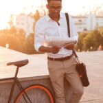 handsome-young-african-man-early-morning-with-bicycle-reading-newspaper_171337-12958