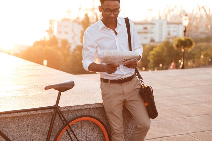 handsome-young-african-man-early-morning-with-bicycle-reading-newspaper_171337-12958
